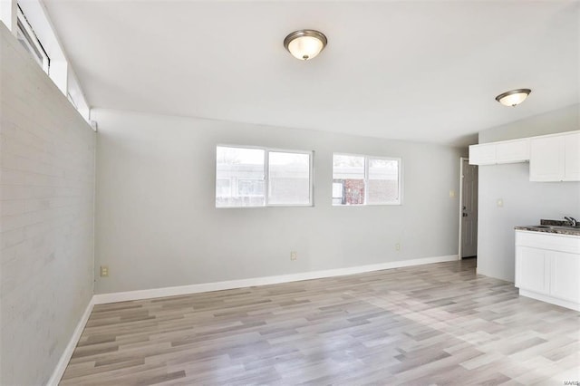 interior space featuring vaulted ceiling, light hardwood / wood-style flooring, and sink