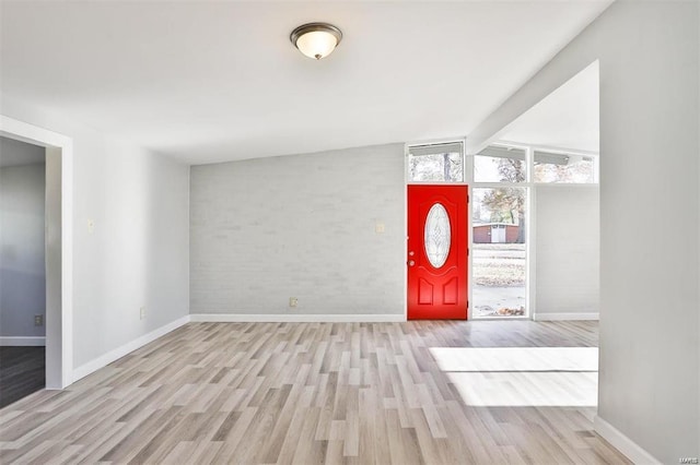 foyer with light wood-type flooring and vaulted ceiling with beams