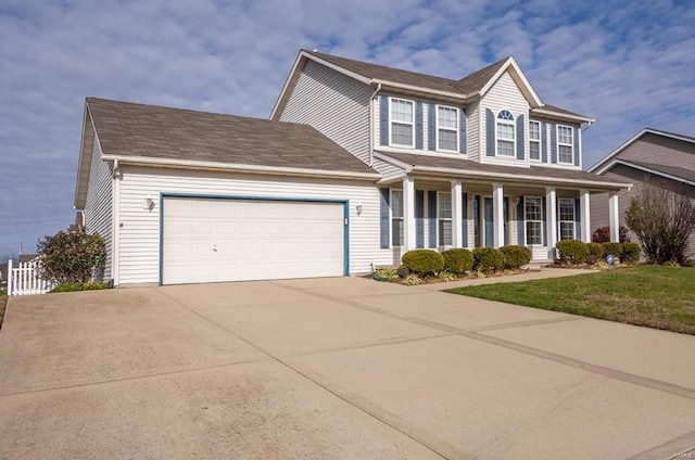 colonial home with a garage, covered porch, and a front lawn