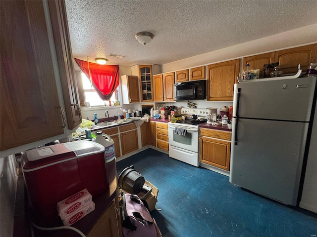 kitchen featuring white electric range oven, stainless steel fridge, a textured ceiling, and sink