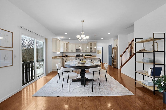 dining room with light wood-type flooring, an inviting chandelier, and sink