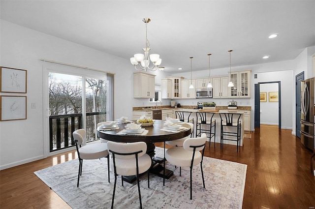 dining area with dark hardwood / wood-style flooring and a notable chandelier