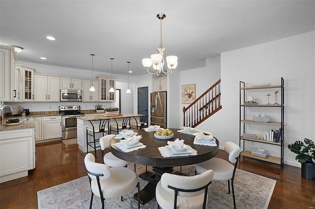 dining area with sink, dark hardwood / wood-style flooring, and a chandelier