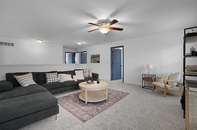 carpeted living room with ceiling fan