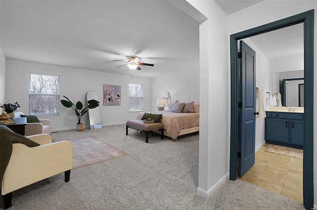 bedroom with ceiling fan, sink, connected bathroom, and light carpet