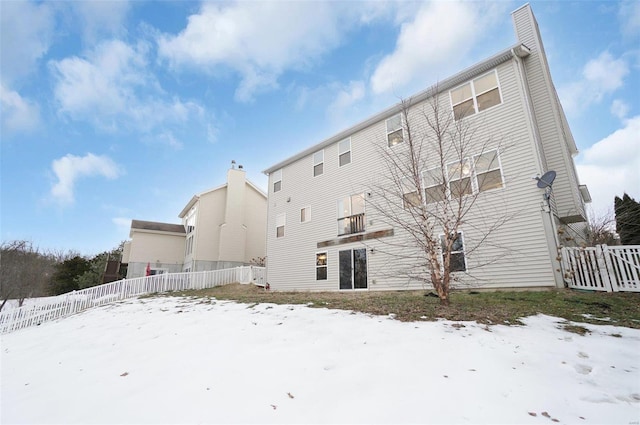 view of snow covered back of property