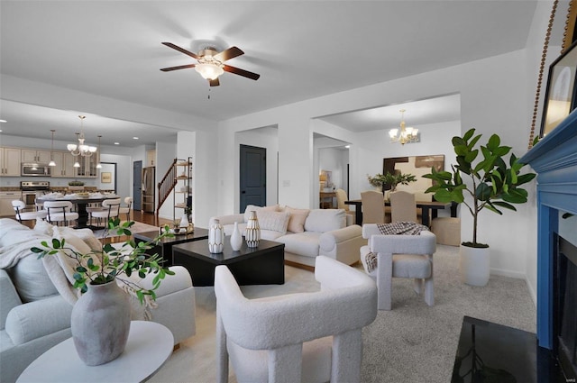 living room with light colored carpet and ceiling fan with notable chandelier