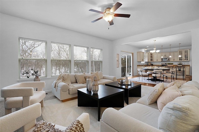 living room featuring ceiling fan with notable chandelier