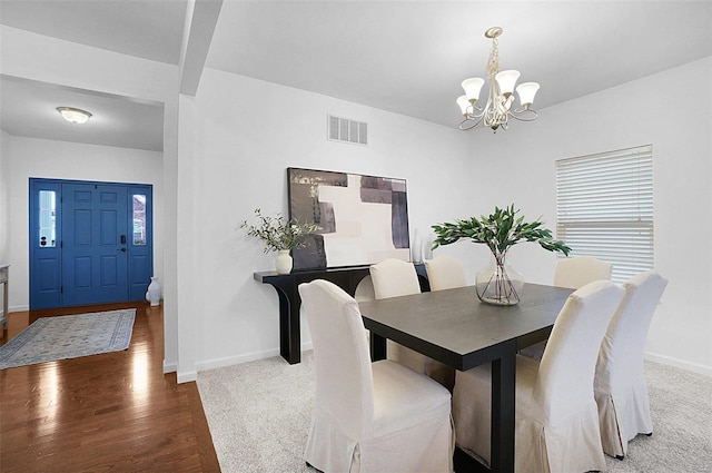 dining space with an inviting chandelier and hardwood / wood-style flooring