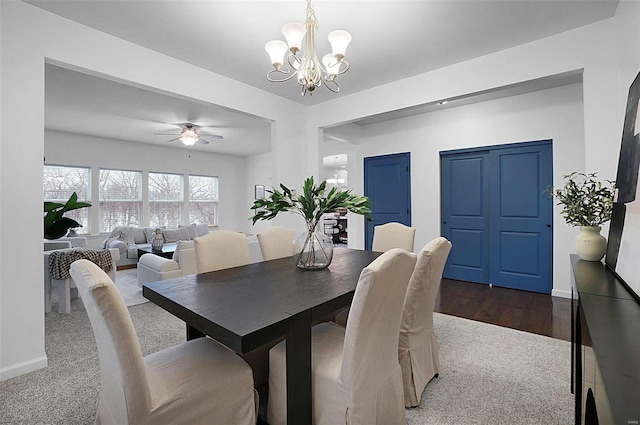 dining room featuring wood-type flooring and ceiling fan with notable chandelier