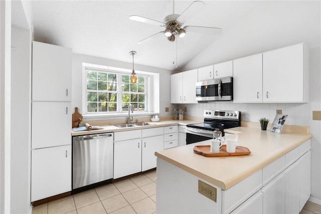 kitchen featuring white cabinets, appliances with stainless steel finishes, sink, vaulted ceiling, and light tile patterned floors