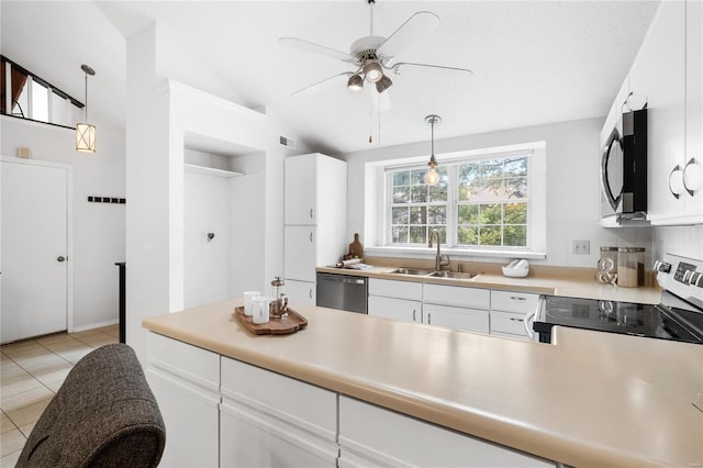 kitchen featuring pendant lighting, appliances with stainless steel finishes, sink, white cabinetry, and lofted ceiling