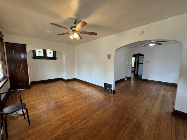 spare room featuring ceiling fan, dark hardwood / wood-style flooring, a healthy amount of sunlight, and a textured ceiling