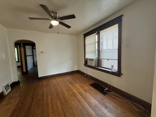 spare room featuring ceiling fan, cooling unit, a textured ceiling, and dark hardwood / wood-style floors