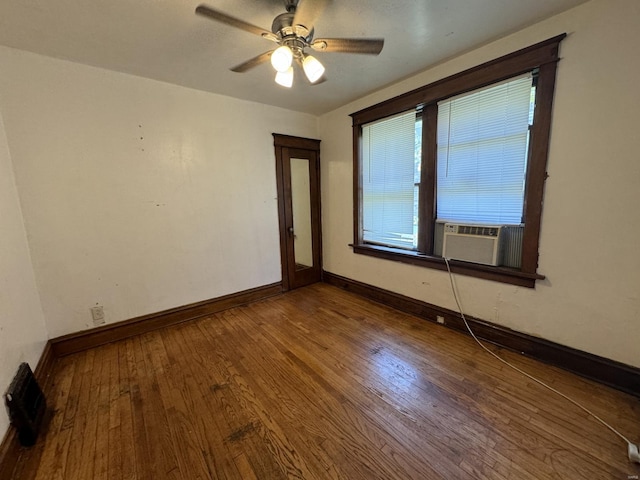 empty room with ceiling fan, cooling unit, and hardwood / wood-style floors