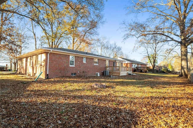 rear view of property with a yard and central AC unit