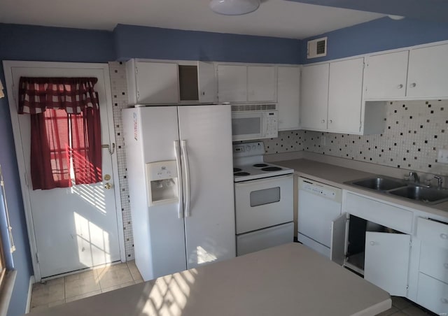 kitchen featuring white appliances, light tile patterned floors, decorative backsplash, white cabinetry, and sink