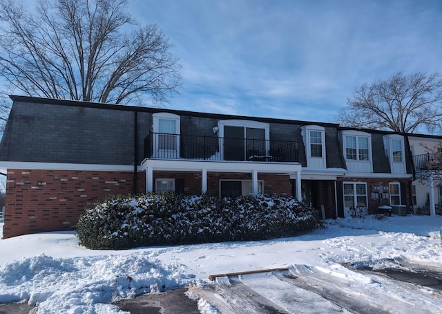 view of front of property featuring a balcony and central AC