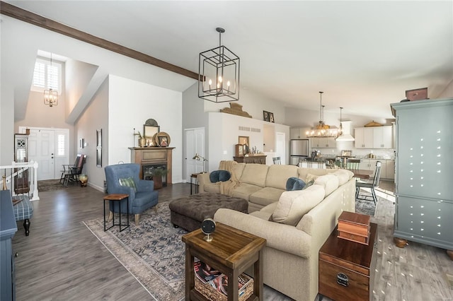 living room with high vaulted ceiling, dark hardwood / wood-style floors, beamed ceiling, and a chandelier