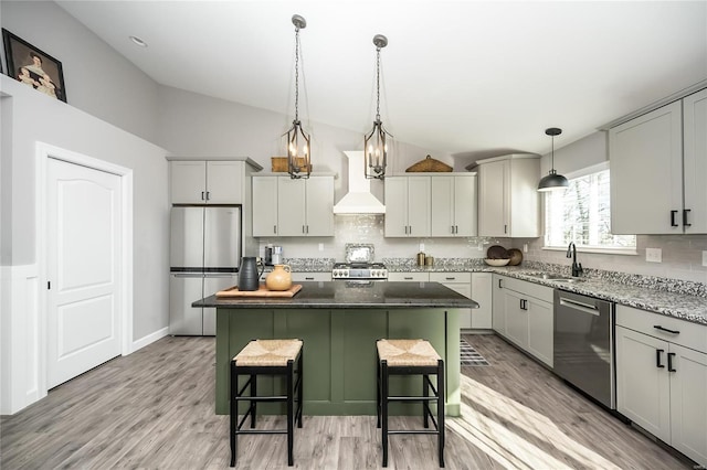 kitchen with appliances with stainless steel finishes, a center island, custom exhaust hood, tasteful backsplash, and a breakfast bar area