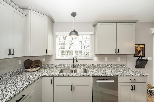 kitchen with backsplash, light stone countertops, pendant lighting, stainless steel dishwasher, and sink