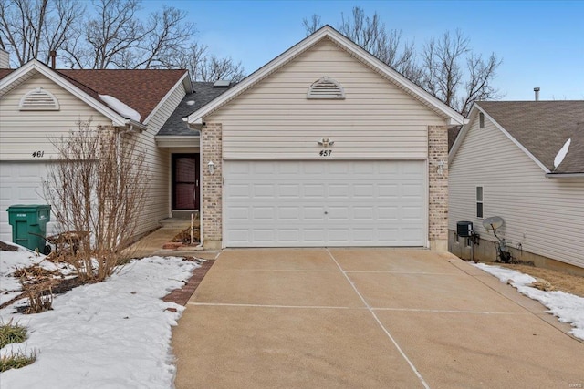 ranch-style house featuring concrete driveway, a garage, and brick siding