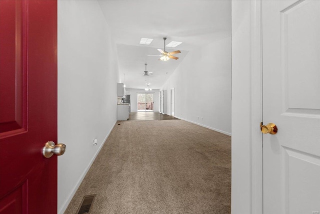 unfurnished living room featuring visible vents, baseboards, a ceiling fan, and carpet flooring