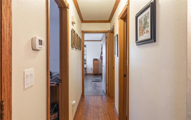 corridor featuring ornamental molding, dark hardwood / wood-style floors, and a textured ceiling