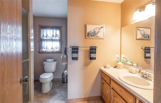 bathroom with vanity, toilet, and a textured ceiling