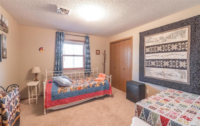 bedroom with carpet flooring, a closet, and a textured ceiling