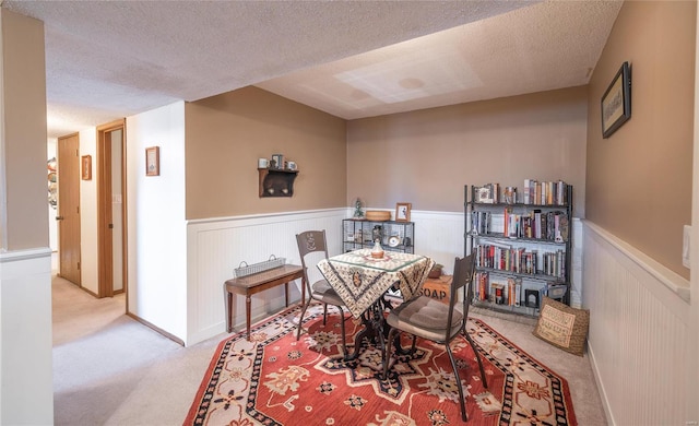 dining space with light carpet and a textured ceiling