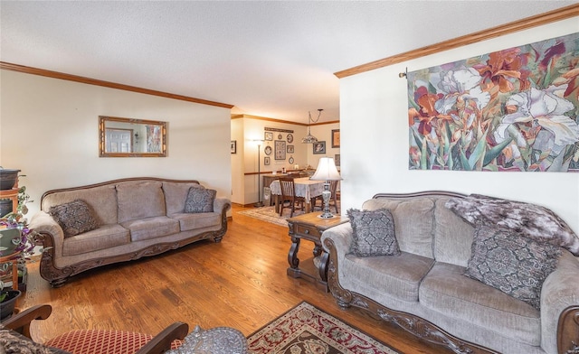 living room with crown molding, a textured ceiling, and light wood-type flooring