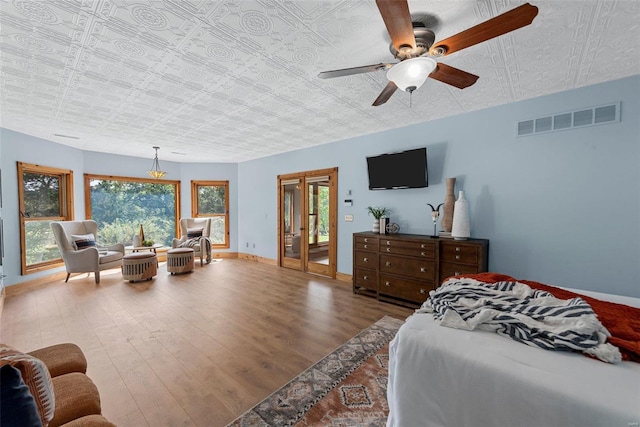 bedroom featuring ceiling fan, hardwood / wood-style floors, and multiple windows