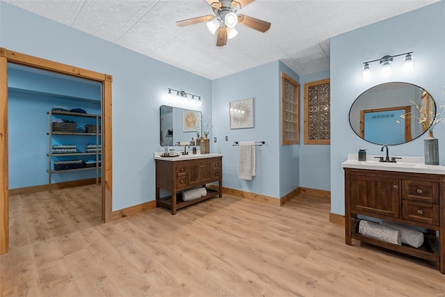 bathroom with wood-type flooring, vanity, and ceiling fan