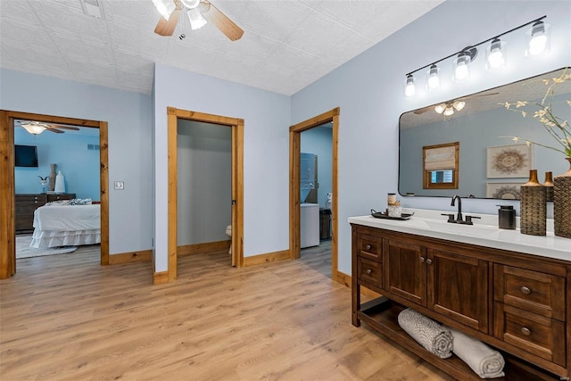 bathroom with hardwood / wood-style flooring, ceiling fan, vanity, and toilet