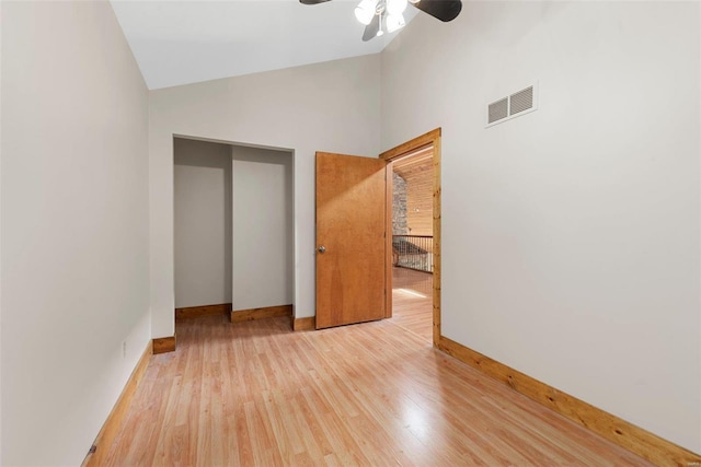 unfurnished bedroom with high vaulted ceiling, ceiling fan, and light hardwood / wood-style flooring