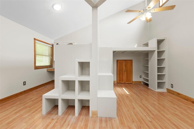 interior space with ceiling fan, high vaulted ceiling, and light wood-type flooring