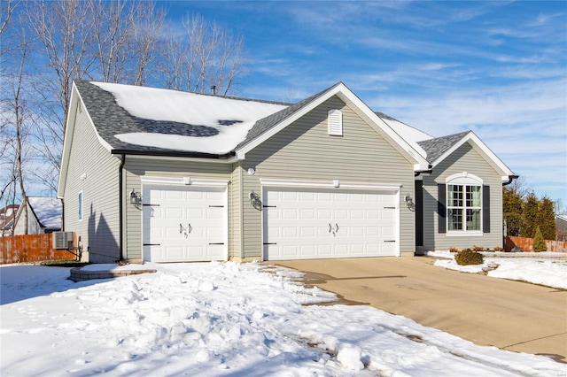 ranch-style home featuring central AC unit and a garage