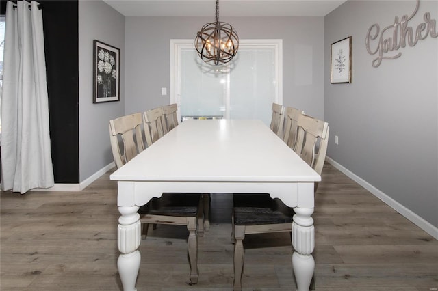 dining area featuring hardwood / wood-style flooring and a notable chandelier