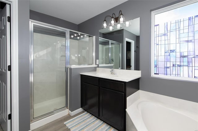 bathroom with vanity, independent shower and bath, and hardwood / wood-style flooring