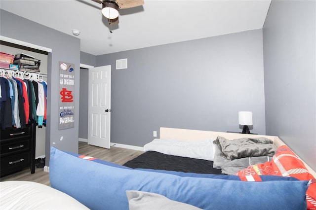 bedroom with ceiling fan, a closet, and light hardwood / wood-style floors