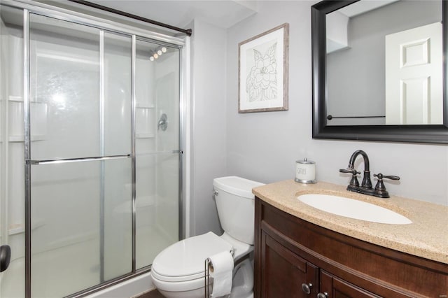 bathroom with toilet, a shower with door, and vanity