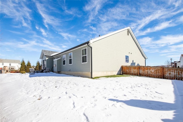 view of snow covered back of property