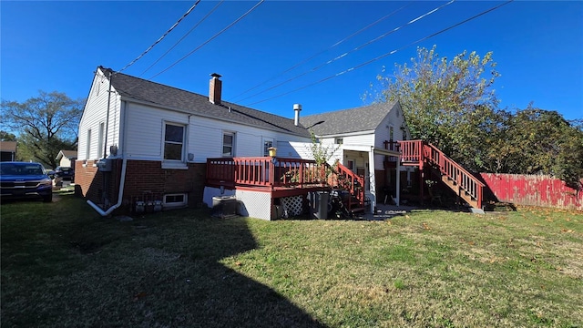 back of property with a yard and a wooden deck