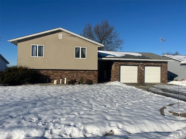 snow covered property featuring a garage