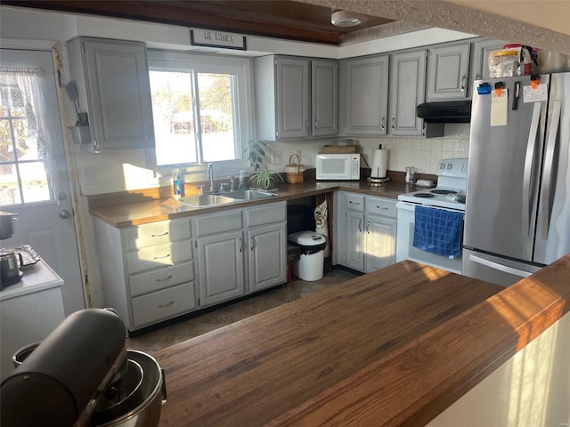 kitchen with sink, white appliances, dark tile patterned flooring, tasteful backsplash, and gray cabinets