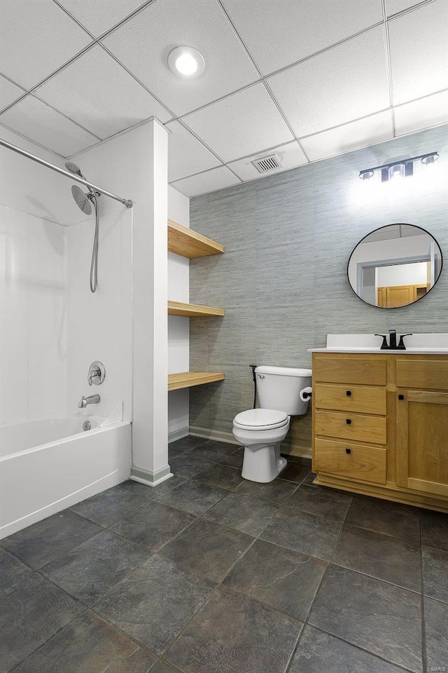 full bathroom featuring washtub / shower combination, toilet, a paneled ceiling, and vanity