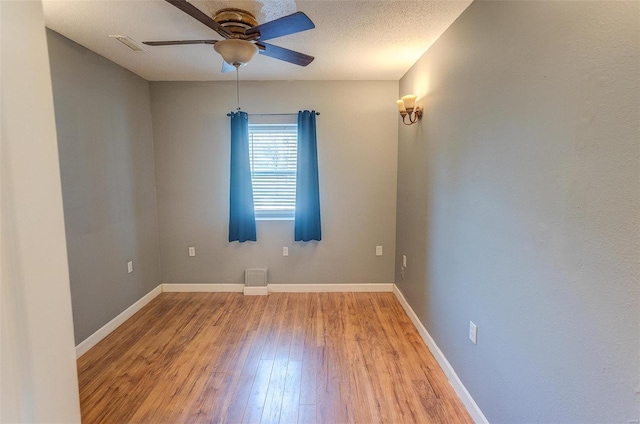 unfurnished room featuring a textured ceiling, wood-type flooring, and ceiling fan