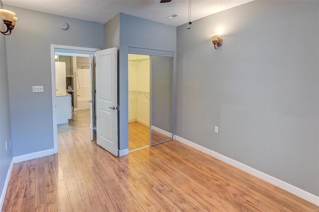 unfurnished bedroom featuring light hardwood / wood-style flooring, a closet, and ceiling fan