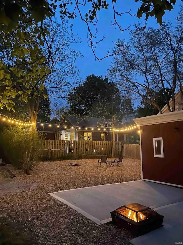 exterior space featuring a patio area, a fire pit, and fence